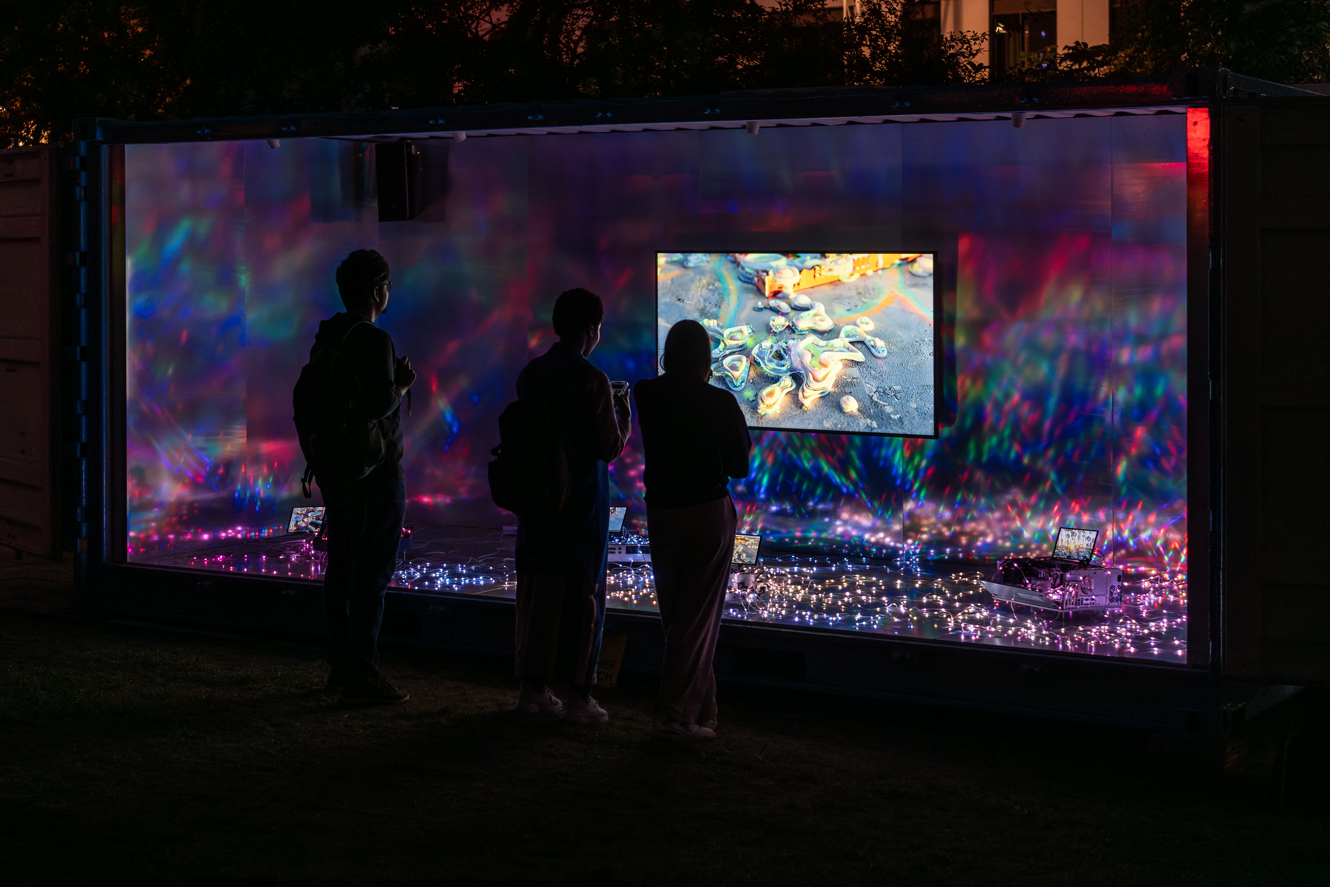 Trois personnes devant une oeuvre de nouveau média de l'artiste Sabrina Ratté