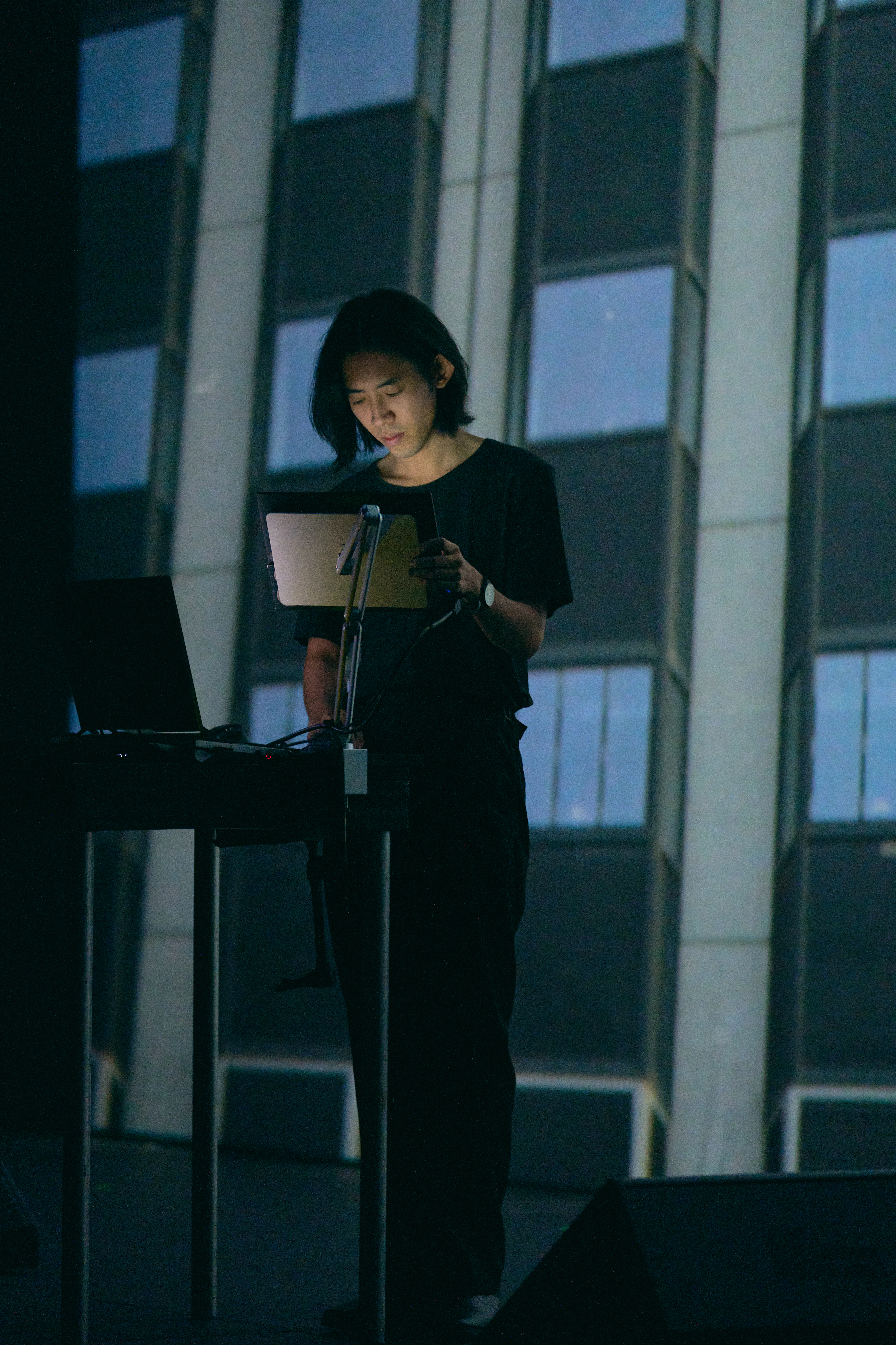 Un artiste en performance audiovisuelle devant un écran